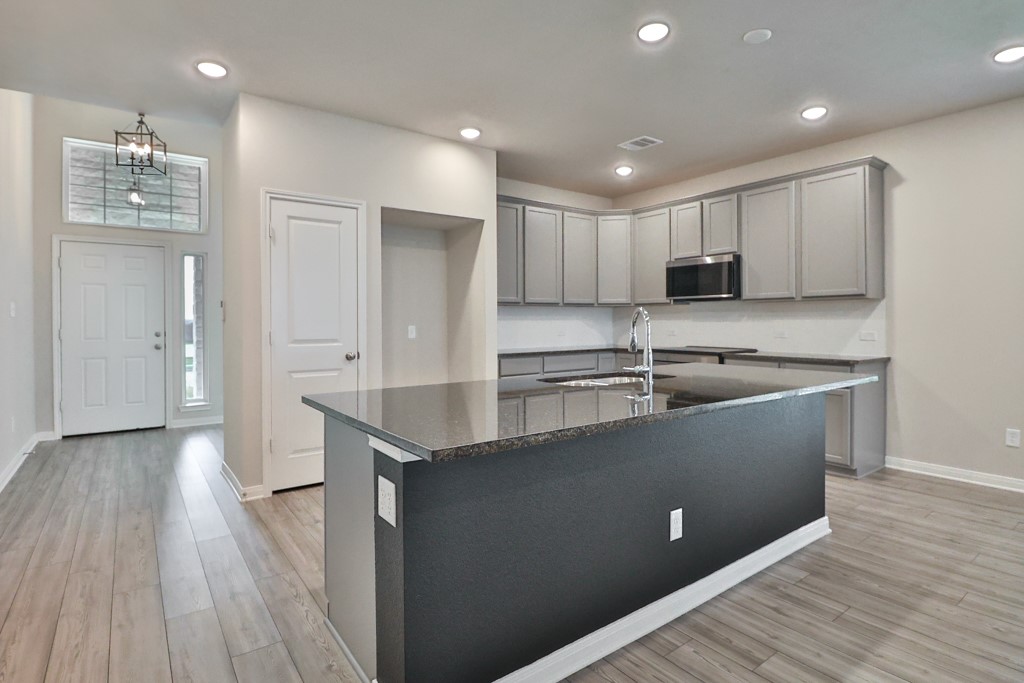 1926 Viva Road Bryan, TX 77807 - Photo 9 of 39 a large kitchen with stainless steel appliances a large counter top a sink a stove a refrigerator and cabinets