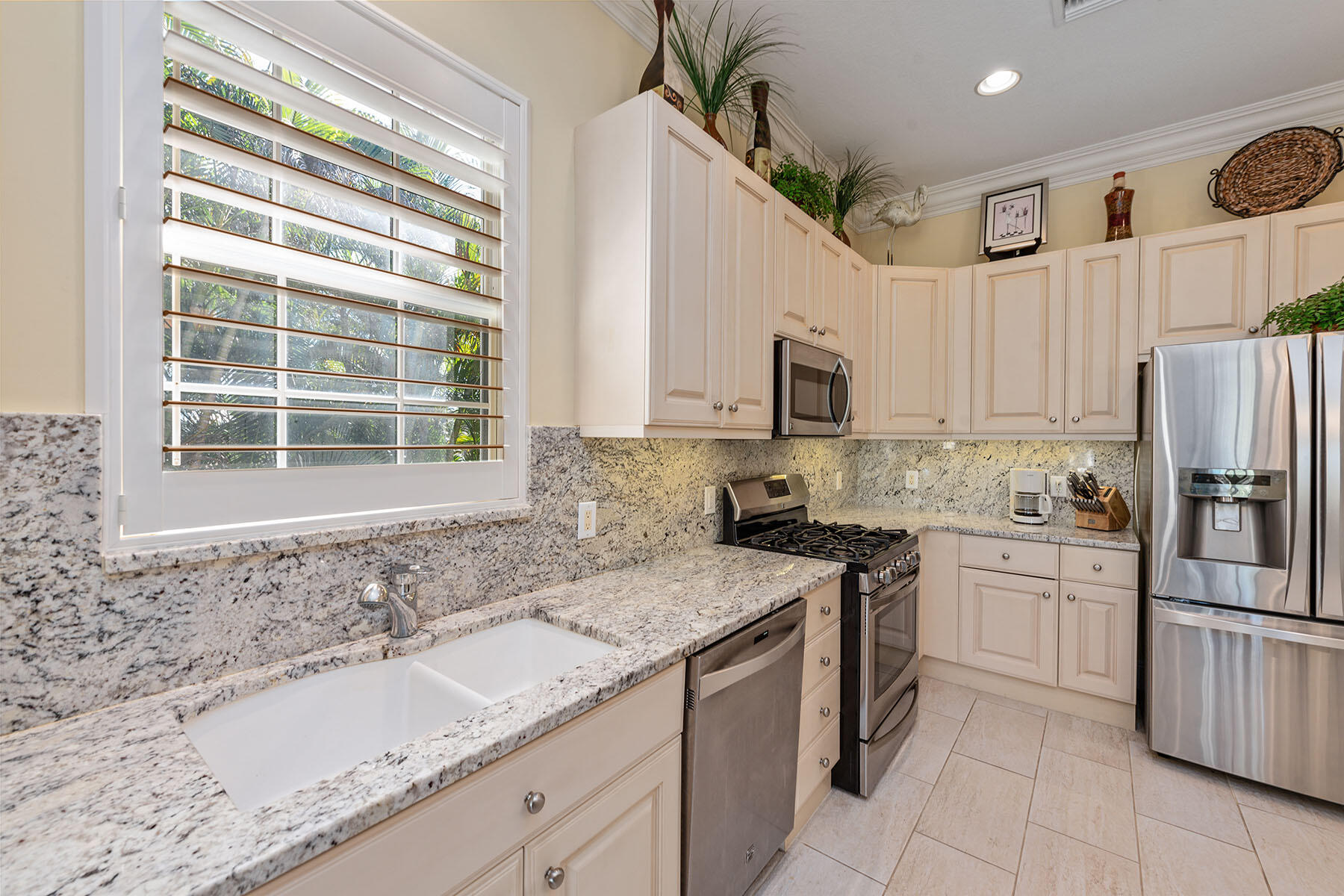 3189 Aviamar Circle, Unit 202 Naples, FL 34114 - Photo 9 of 50 a kitchen with granite countertop a sink stainless steel appliances and cabinets