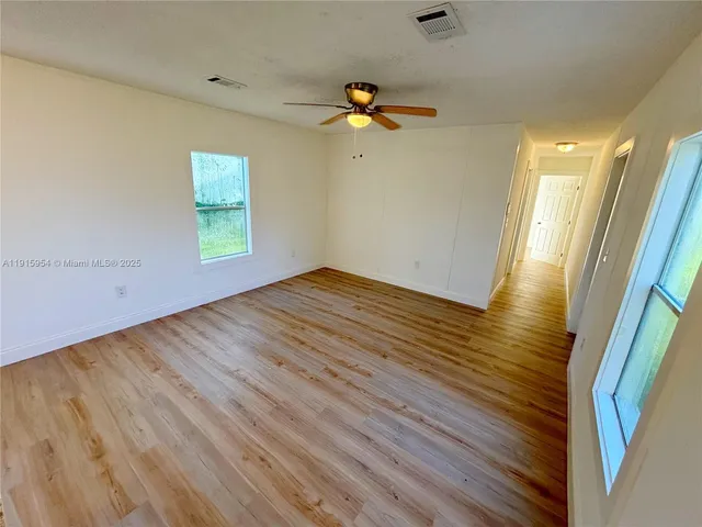 a view of empty room with wooden floor