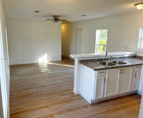 a view of granite countertop cabinets and wooden floor