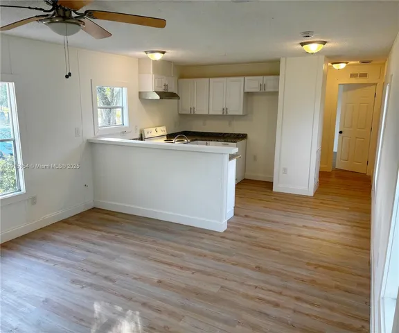 a view of kitchen with granite countertop cabinets and wooden floor