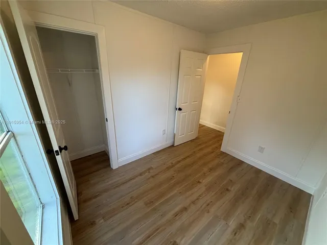 an empty room with wooden floor and closet