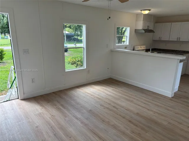 a view of a kitchen with wooden floor and electronic appliances