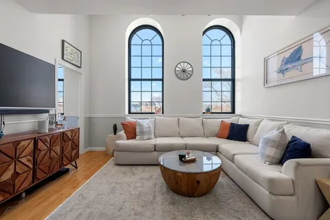 a living room with furniture a flat screen tv and a large window