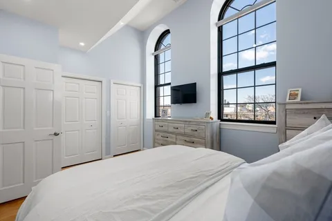 a bedroom with a bed and a flat tv screen on dresser