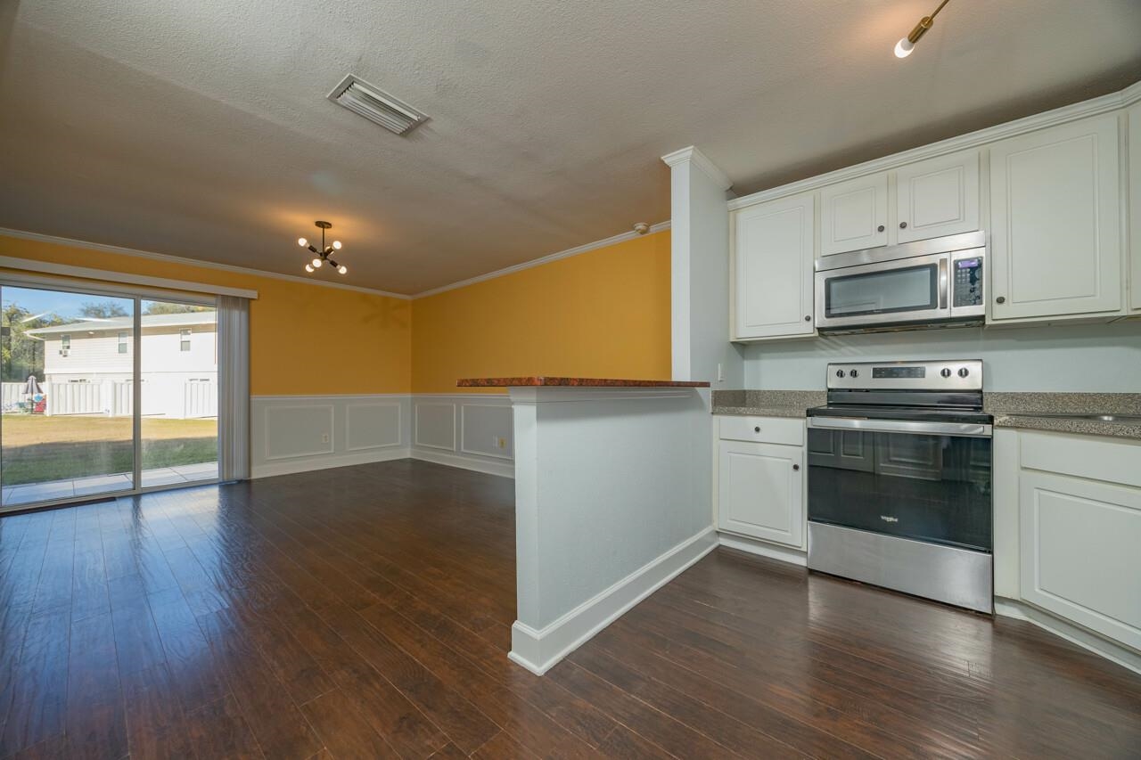 4420 Carter Road, Unit 27 St. Augustine, FL 32086 - Photo 4 of 30 a kitchen with stainless steel appliances a stove a microwave and cabinets