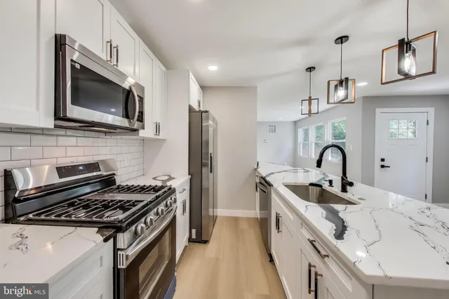 a kitchen with stainless steel appliances granite countertop a sink and a stove