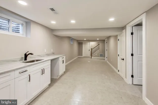 a view of a hallway with white cabinets