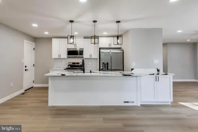 a view of kitchen with stainless steel appliances refrigerator stove microwave and cabinets