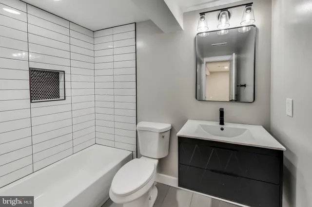 a bathroom with a toilet a sink and mirror