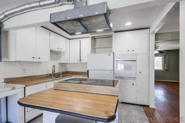 a kitchen with granite countertop white cabinets and a sink