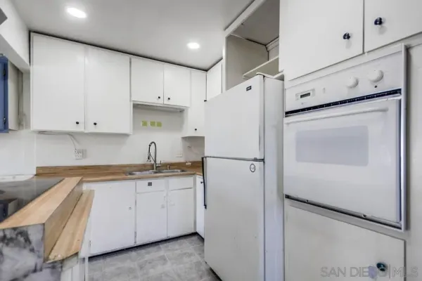 a kitchen with granite countertop white cabinets and a sink