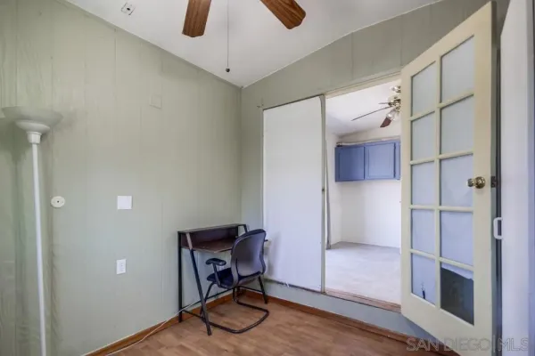 an empty room with wooden floor exposed radiator and windows