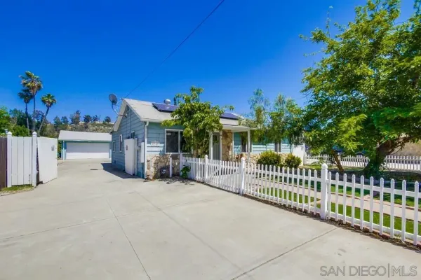 a view of a house with a wooden fence
