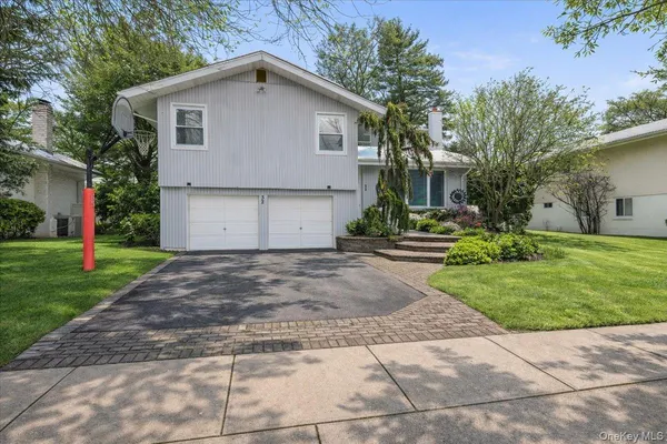 a view of a house with a yard and large tree