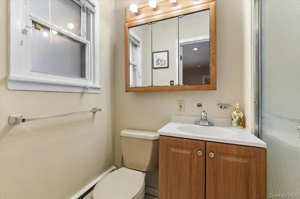 a bathroom with a toilet sink and mirror