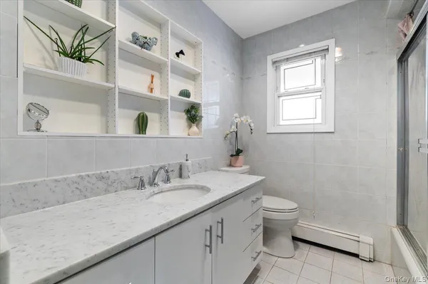 a bathroom with a granite countertop sink a toilet and a mirror