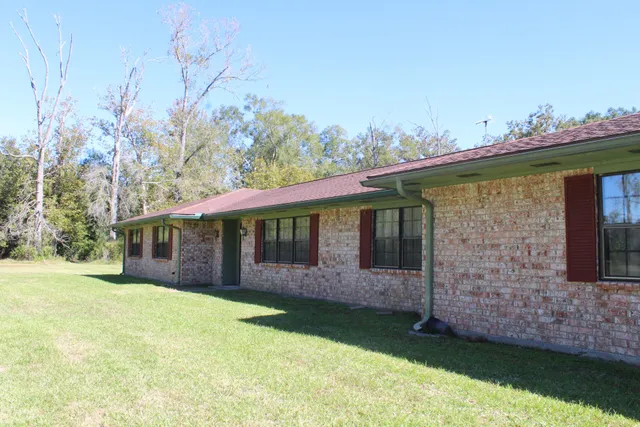a view of a house with backyard and sitting area