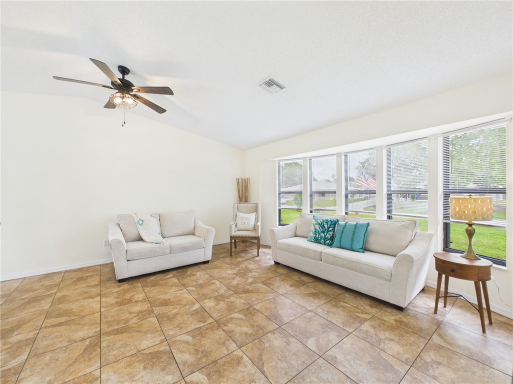 225 Midvale Terrace Sebastian, FL 32958 - Photo 4 of 25 a living room with furniture and a floor to ceiling window