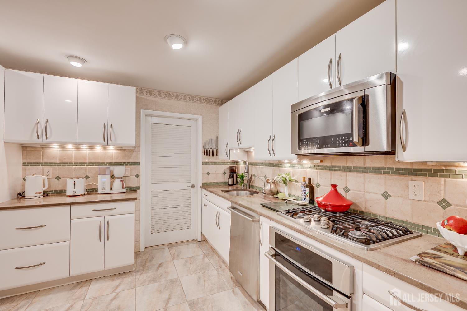 114 Coppertree Court Edison, NJ 08820 - Photo 17 of 47 a kitchen with stainless steel appliances a sink stove and cabinets