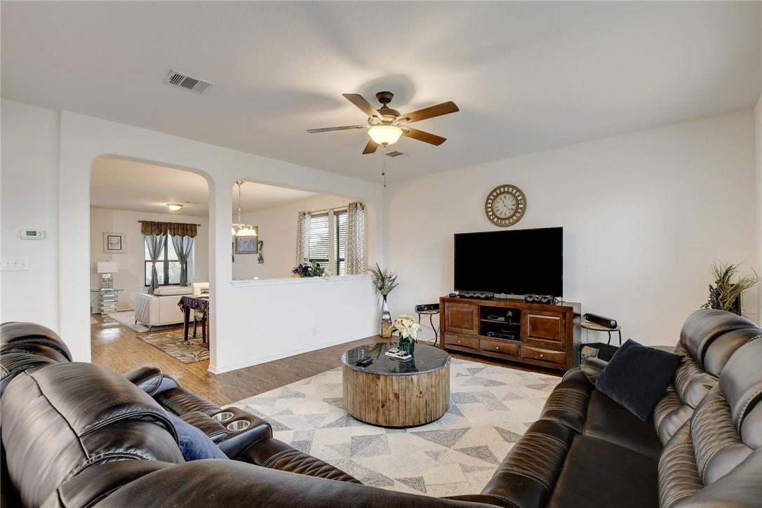 356 Matthews Kyle, TX 78640 - Photo 27 of 30 An open concept living room with warm wood flooring flows seamlessly into the adjacent dining area.