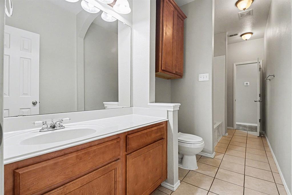 1021 Comfort Drive Forney, TX 75126 - Photo 15 of 37 a bathroom with a sink a toilet and a mirror