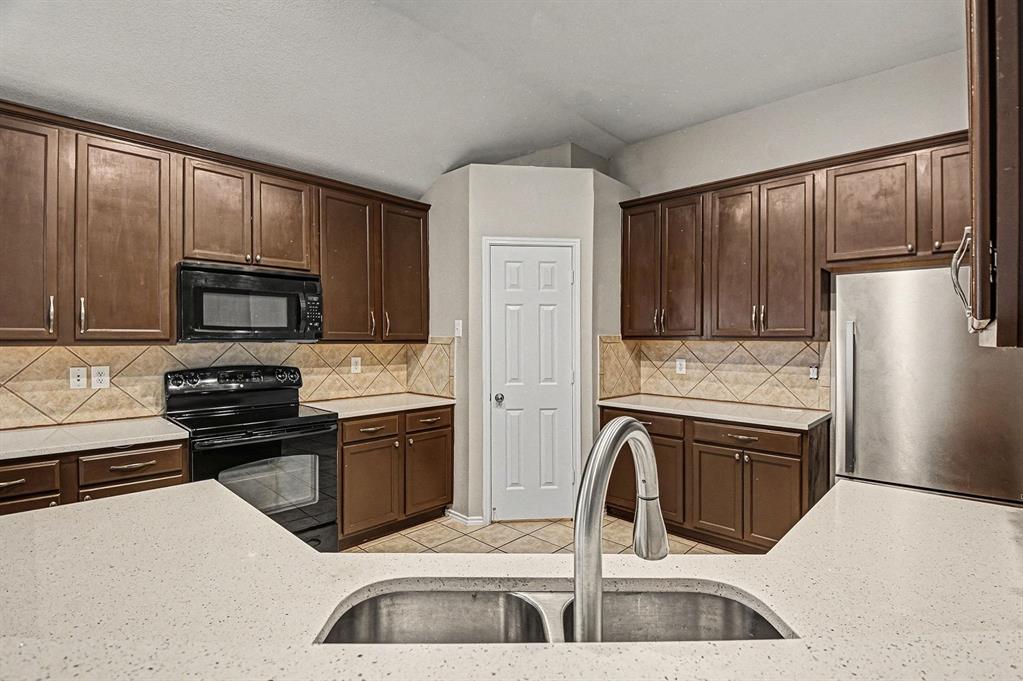 1021 Comfort Drive Forney, TX 75126 - Photo 21 of 37 a kitchen with stainless steel appliances granite countertop a refrigerator stove and sink