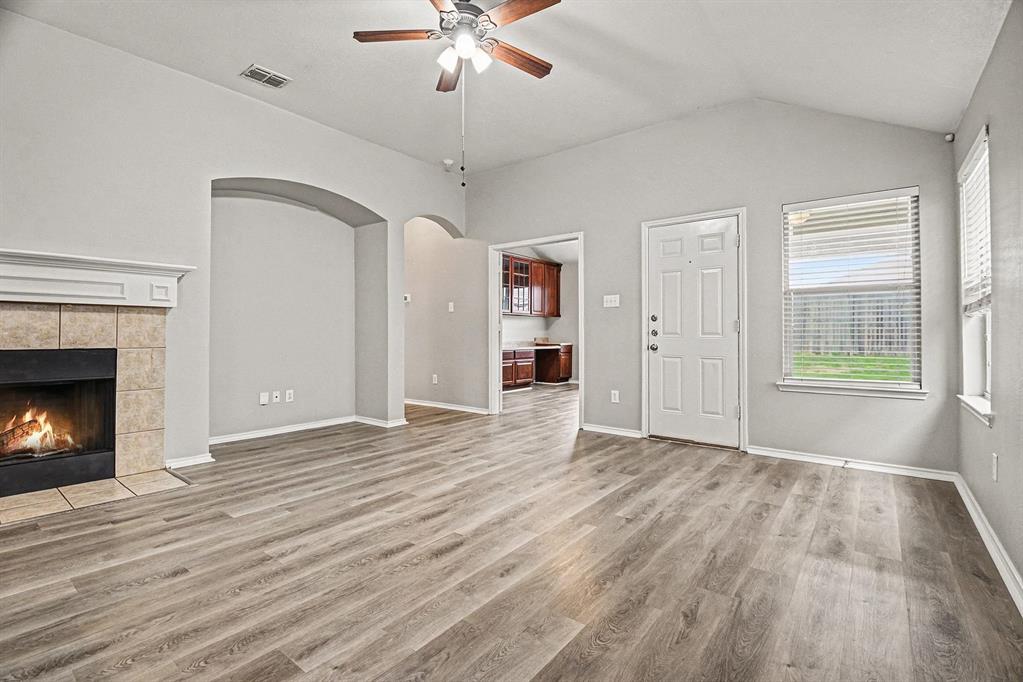 1021 Comfort Drive Forney, TX 75126 - Photo 9 of 37 a view of an empty room with wooden floor fireplace and a window