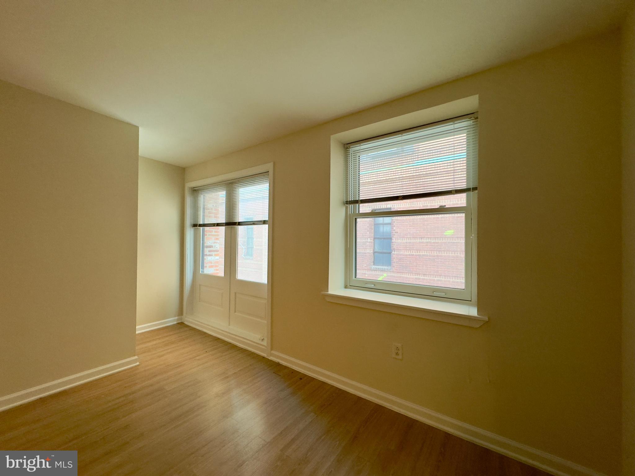 413 North Howard Street, Unit 204 Baltimore, MD 21201 - Photo 6 of 13 a view of an empty room with wooden floor and a window