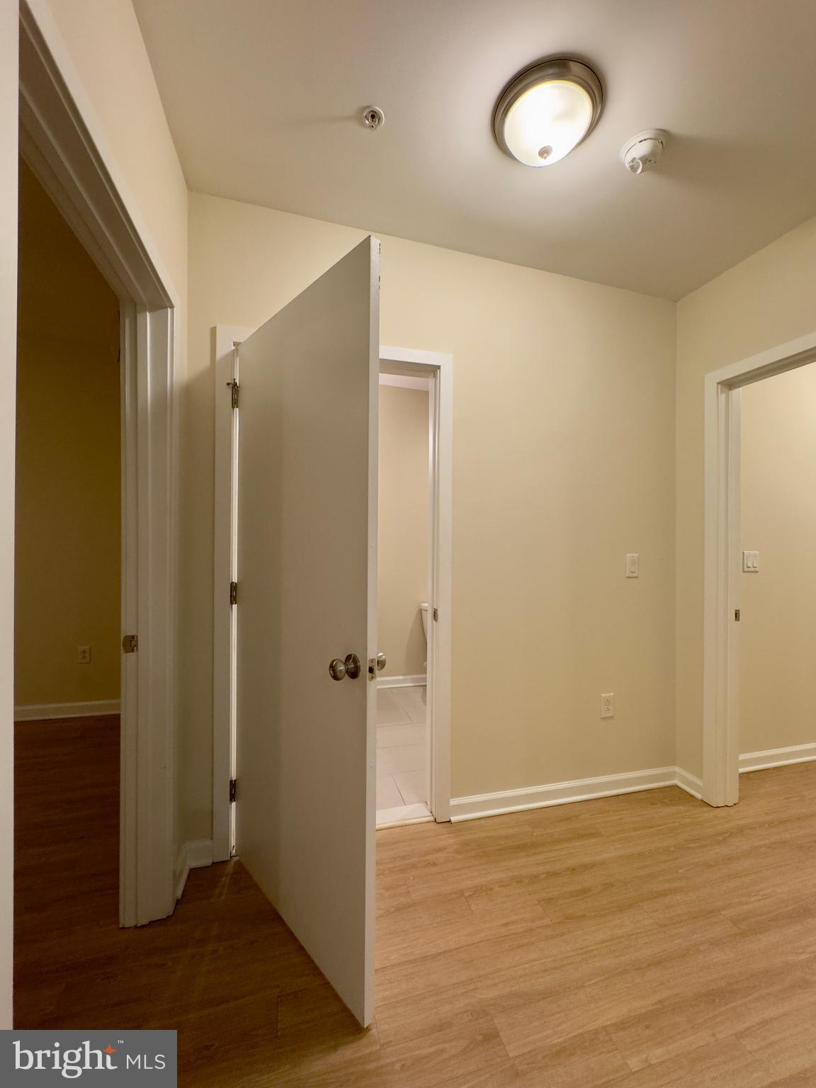 413 North Howard Street, Unit 204 Baltimore, MD 21201 - Photo 8 of 13 an empty room with wooden floor and windows