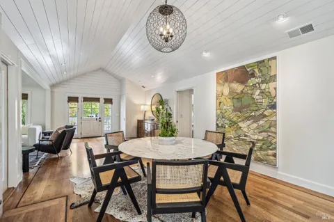 a kitchen with a stove a refrigerator a sink dishwasher with a dining table and chairs with wooden floor