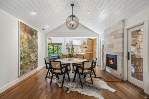 a dining room with furniture a fireplace and wooden floor