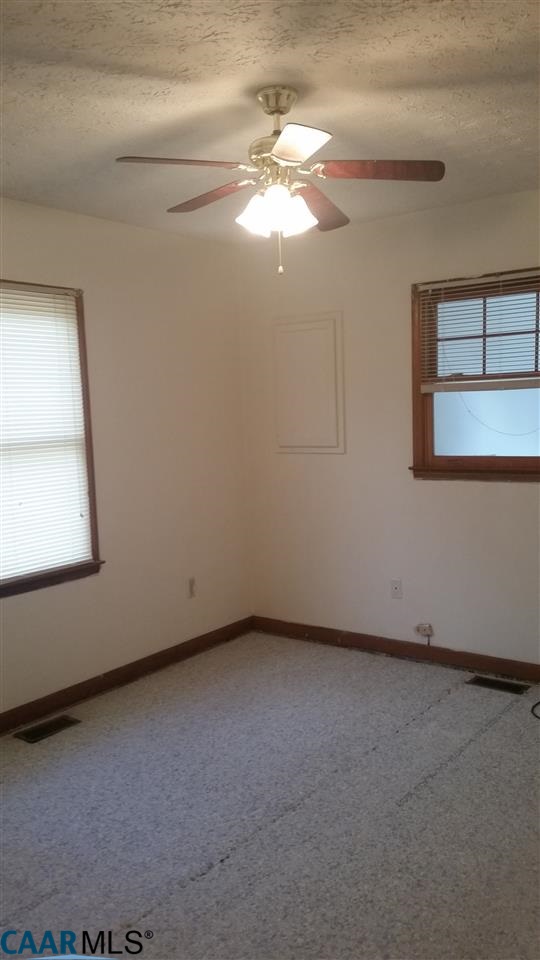 6601 Courthouse Road Louisa, VA 23093 - Photo 20 of 36 an empty room with a chandelier fan and windows
