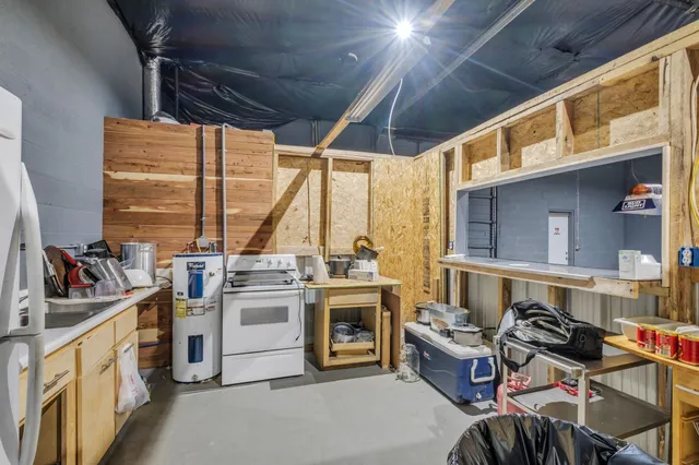 a view of a kitchen with stainless steel appliances granite countertop a stove and a window