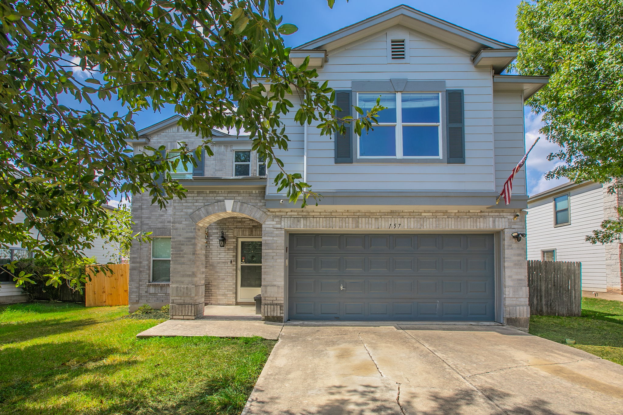 157 Lex Word Kyle, TX 78640 - Photo 1 of 34 A classic stone and siding exterior integrates a spacious two-car garage under a gabled roofline.