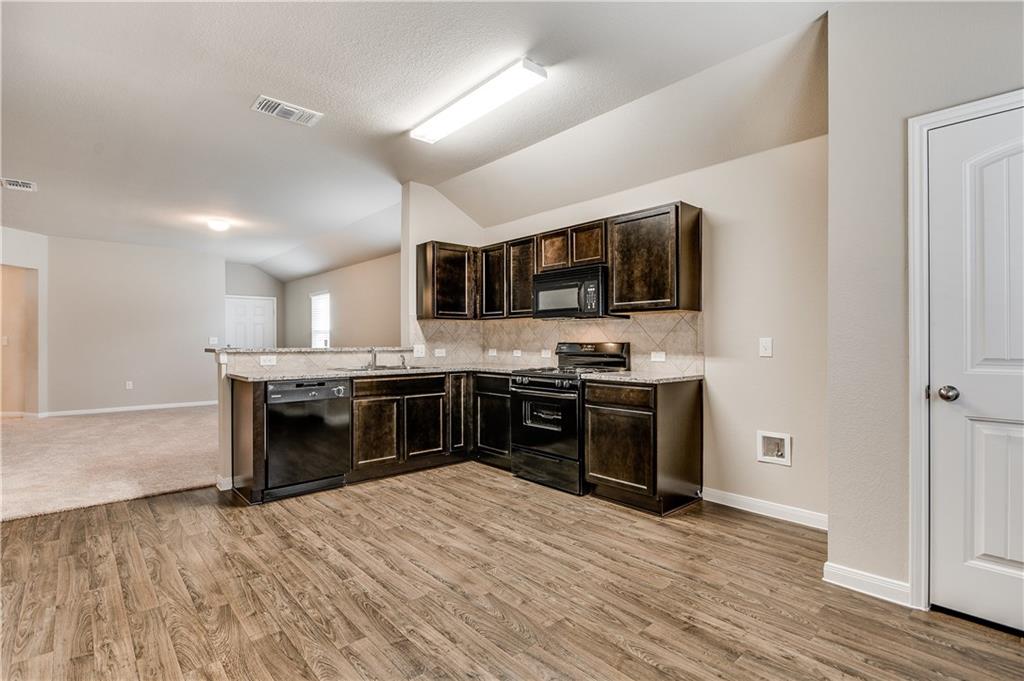 185 Voss Kyle, TX 78640 - Photo 6 of 26 a kitchen with stainless steel appliances and a wooden floor
