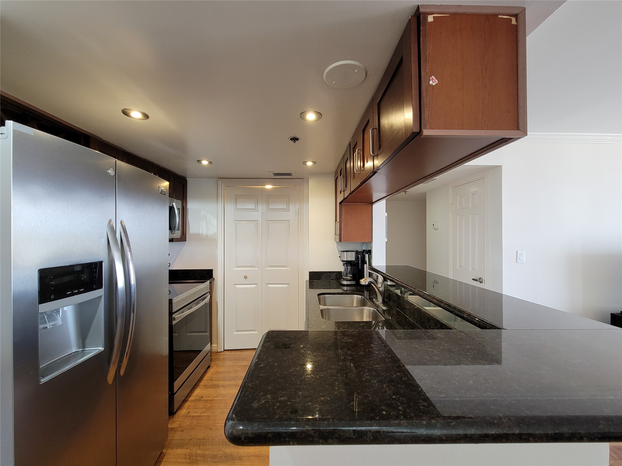 3525 Sage Road, Unit 1605 Houston, TX 77056 - Photo 8 of 33 a kitchen with stainless steel appliances granite countertop a refrigerator a stove and a sink with wooden floor