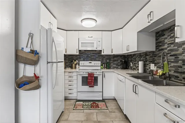 a kitchen with white cabinets and white appliances