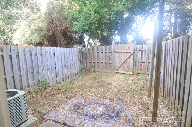a view of a yard with wooden fence