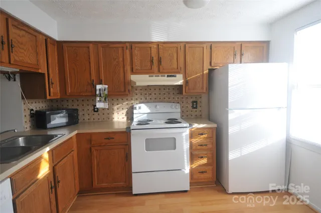 a kitchen with a white stove top oven and refrigerator