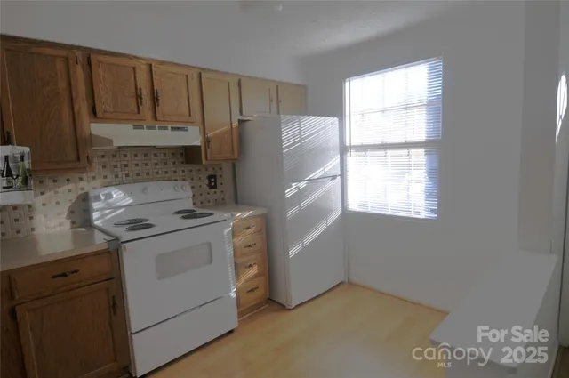 a kitchen with a stove a refrigerator and a window