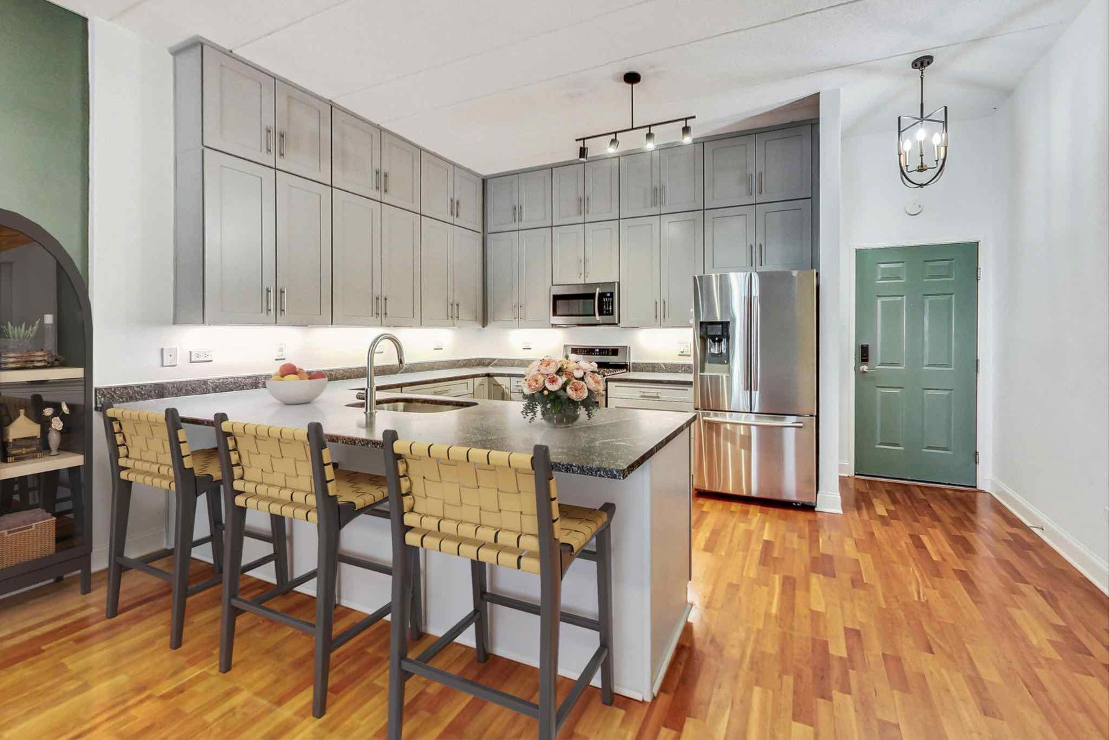 1301 West Washington Boulevard, Unit 208 Chicago, IL 60607 - Photo 11 of 37 a kitchen with kitchen island granite countertop a sink cabinets and stainless steel appliances
