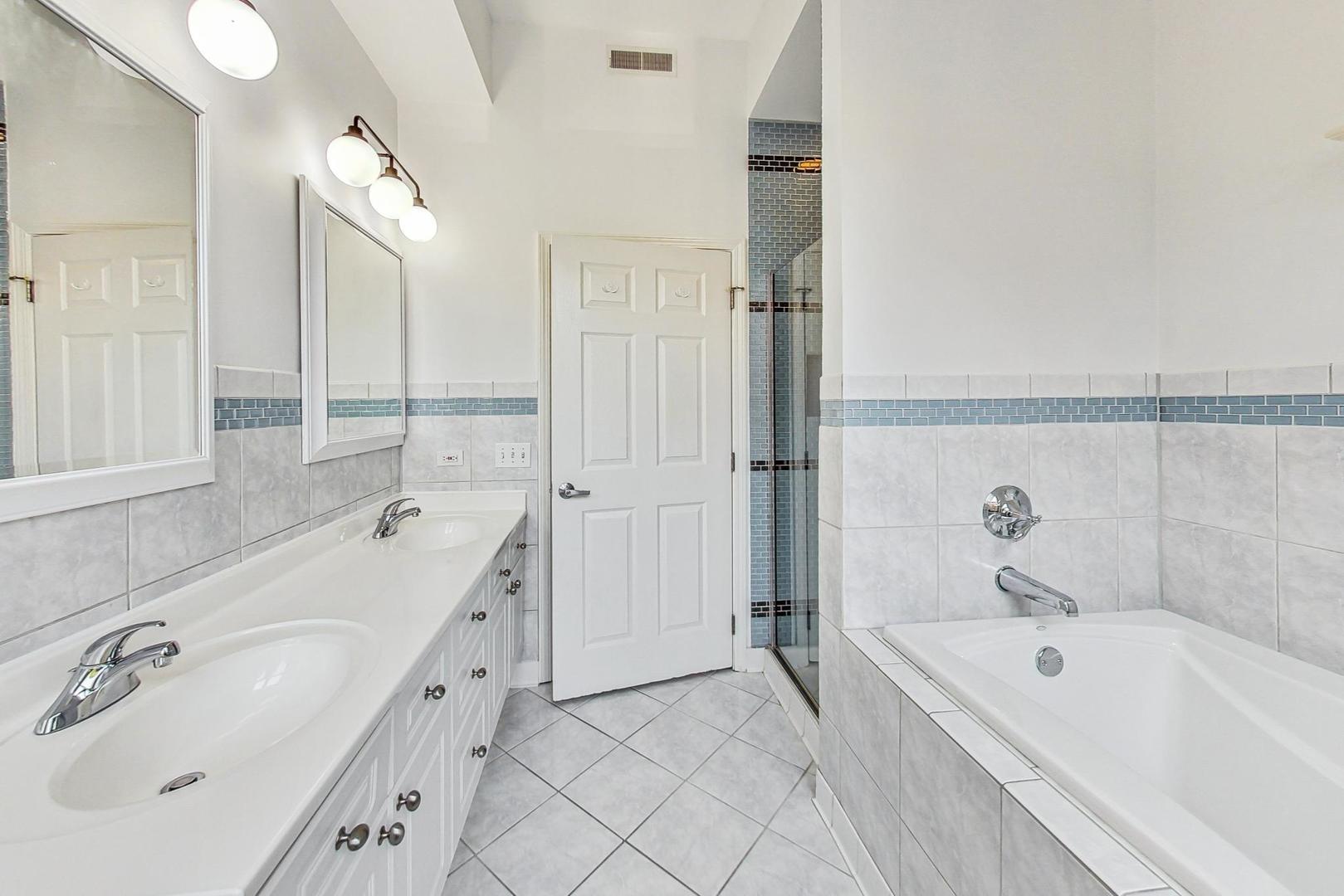 1301 West Washington Boulevard, Unit 208 Chicago, IL 60607 - Photo 19 of 37 a bathroom with a tub sink and mirror