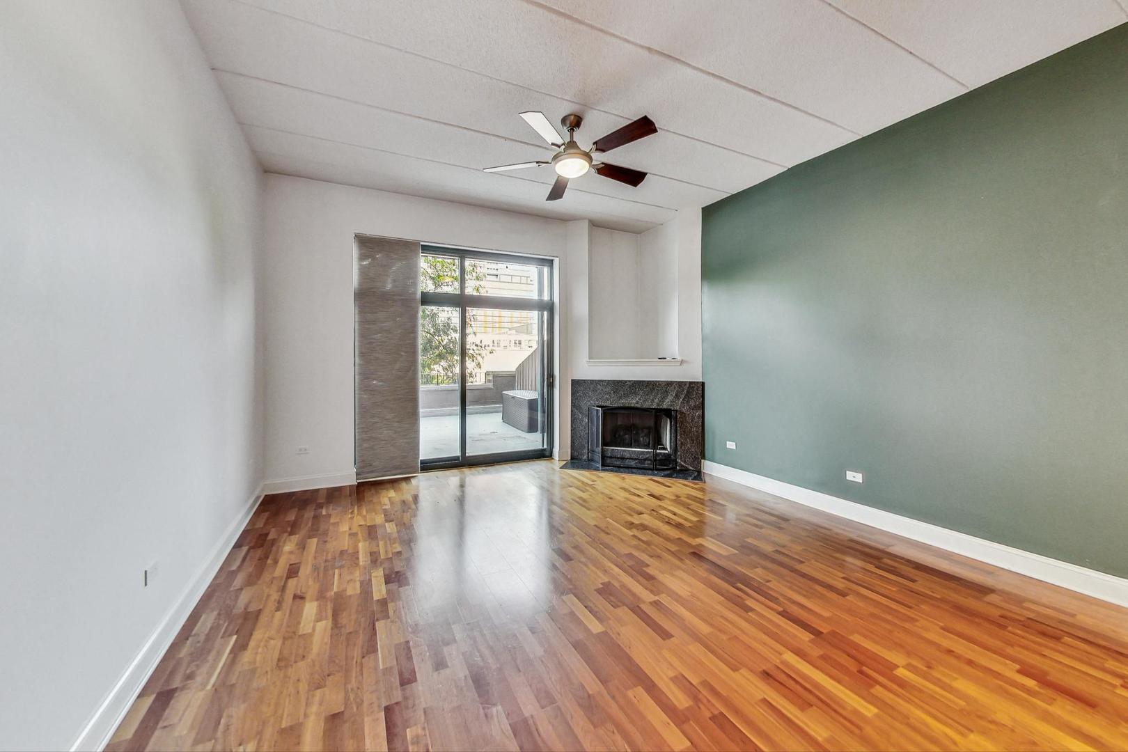 1301 West Washington Boulevard, Unit 208 Chicago, IL 60607 - Photo 4 of 37 a view of an empty room with wooden floor fireplace and a window