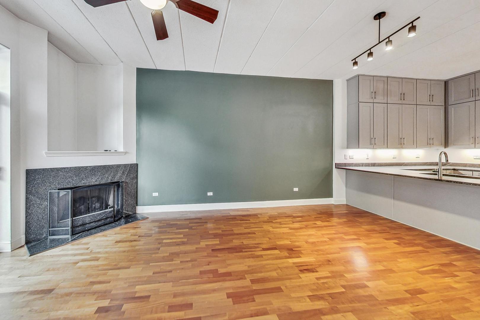 1301 West Washington Boulevard, Unit 208 Chicago, IL 60607 - Photo 6 of 37 a view of an empty room with a fireplace and a window
