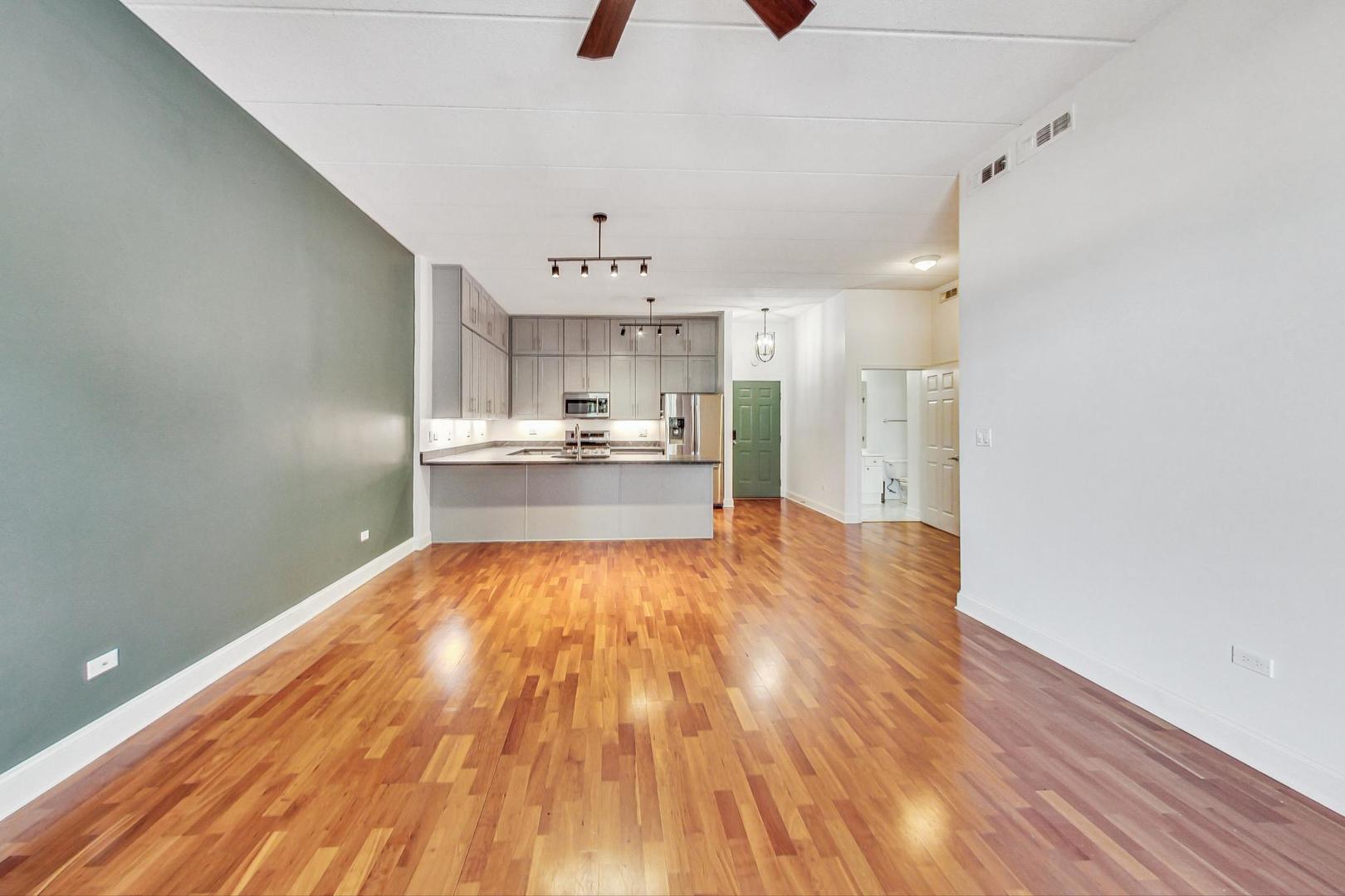 1301 West Washington Boulevard, Unit 208 Chicago, IL 60607 - Photo 10 of 37 a view of a kitchen with a stove and wooden floor