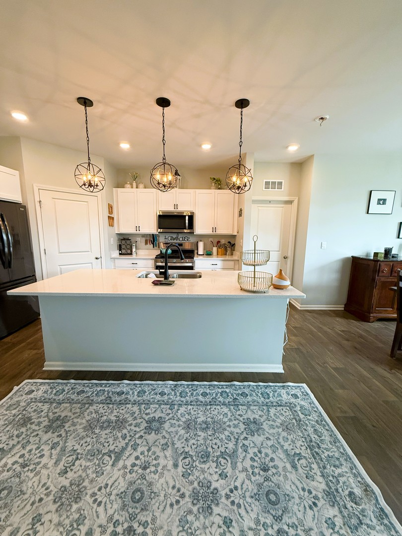 6323 Aspen Lane Wonder Lake, IL 60097 - Photo 3 of 17 a large kitchen with kitchen island sink stove and wooden floor