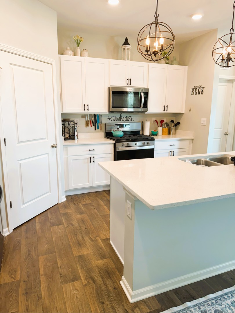 6323 Aspen Lane Wonder Lake, IL 60097 - Photo 6 of 17 a kitchen with stainless steel appliances a white stove top oven cabinets and a chandelier