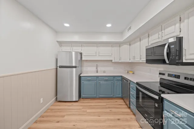 a kitchen with stainless steel appliances granite countertop a refrigerator and a stove top oven