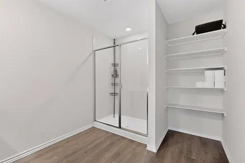 a view of an empty room with wooden floor